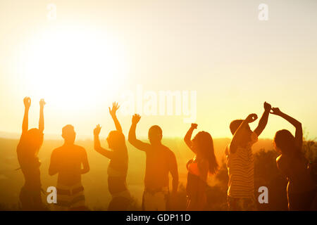 Amici partying al tramonto durante le vacanze estive Foto Stock