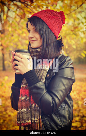 Ragazza con caffè in tazza monouso. Foto Stock