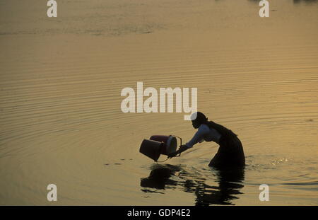 Una donna a prendere l'acqua dal lago al Prasat Prei tempio di Angkor presso la cittadina di Siem riep in Cambogia in southeastasia. Foto Stock