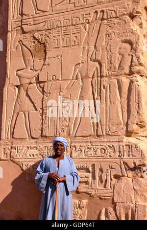 Una guardia in posa di fronte oh geroglifici nel tempio di Karnak Luxor Egitto Foto Stock