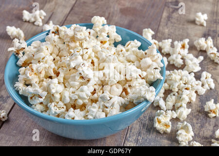Vaso blu con popcorn su sfondo di legno. Foto Stock
