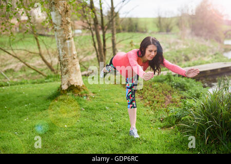 Donna incinta all'aperto in posizione di yoga Foto Stock