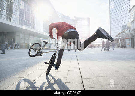 BMX Biker facendo stunt in area urbana Foto Stock