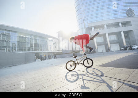 BMX Biker facendo stunt in area urbana Foto Stock