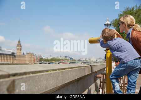 Madre e figlio utilizzando a gettone binocolo Foto Stock