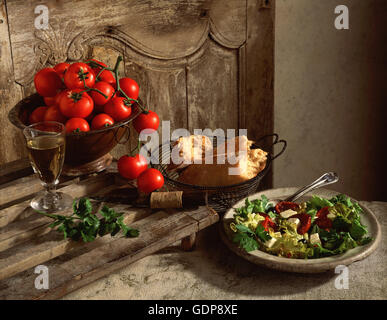 Display tradizionale della cucina mediterranea, pomodori, ciabatta pane, insalata di formaggio feta, pomodori secchi, insalata, vino Foto Stock