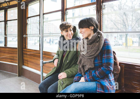 Due donne sorelle seduti sulla funivia, sorridente Foto Stock