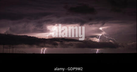 Two cloud-to-ground lightning bolts shoot through the low clouds of a supercell Foto Stock