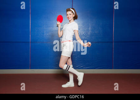 Ping-pong player in posa con bat e sfera Foto Stock