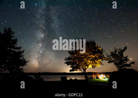 Gli amici seduti al falò e la via lattea, Malay Falls, Nova Scotia, Canada Foto Stock