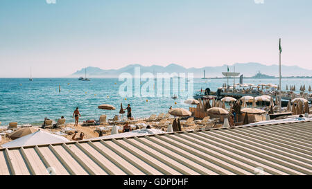 Spiaggia sdraio. Chaise-longue sulla spiaggia. Lettino e ombrellone sulla spiaggia di Cannes, Francia. Foto Stock