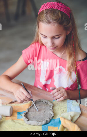 Ragazza rendendo il suo primo ceramica in laboratorio di ceramica Foto Stock