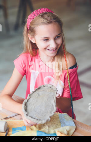 Ragazza rendendo il suo primo ceramica in laboratorio di ceramica Foto Stock