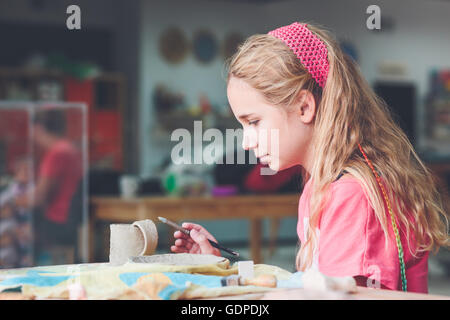 Ragazza rendendo il suo primo ceramica in laboratorio di ceramica Foto Stock