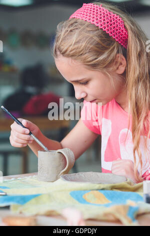 Ragazza rendendo il suo primo ceramica in laboratorio di ceramica Foto Stock