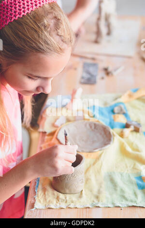 Ragazza rendendo il suo primo ceramica in laboratorio di ceramica Foto Stock