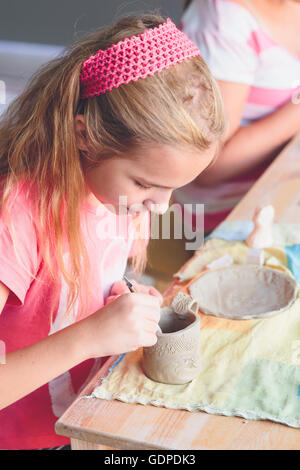 Ragazza rendendo il suo primo ceramica in laboratorio di ceramica Foto Stock