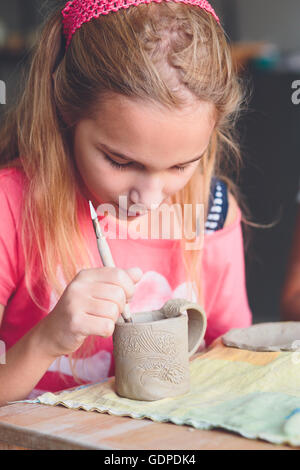 Ragazza rendendo il suo primo ceramica in laboratorio di ceramica Foto Stock