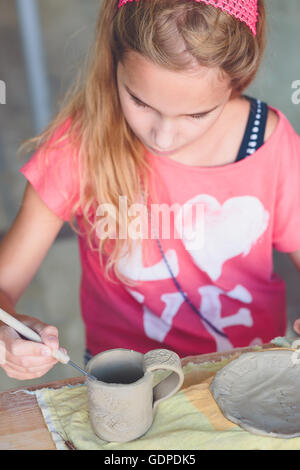 Ragazza rendendo il suo primo ceramica in laboratorio di ceramica Foto Stock