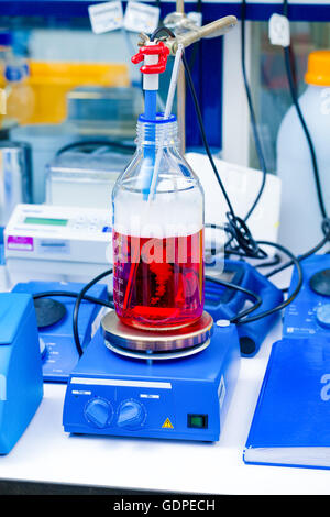 Bottiglia con liquido rosso in laboratorio Foto Stock