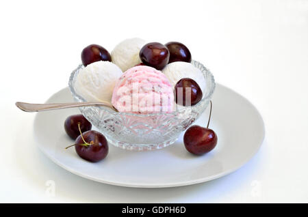 La ciliegia del gelato e gelato alla vaniglia con ciliegie fresche in una ciotola, close up, macro, sfondo bianco Foto Stock