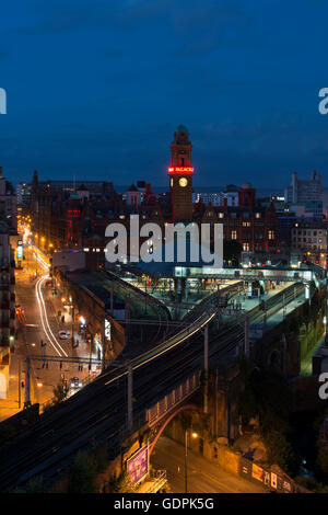 Lo skyline di Manchester con il traffico stradale e i treni nei pressi di Oxford Road station da Whitworth Street West nel centro della città di notte. Foto Stock