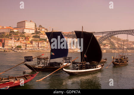 Il vino di Porto imbarcazioni presso il lungomare con il Ponte de Dom Luis 1 e dalla parte vecchia della città sul fiume Douro in Ribeira nella città di ce Foto Stock