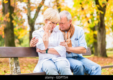 Senior di un uomo e di una donna che un essere triste che abbraccia ogni altro Foto Stock