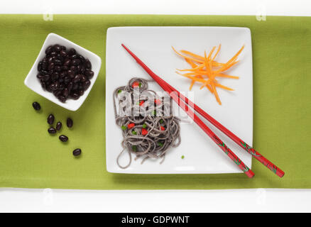 Nero e fagiolo fagiolo nero Spaghetti guarnita con carote Foto Stock