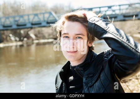 Teen siede al di fuori vicino al ponte di una giacca di pelle. Foto Stock