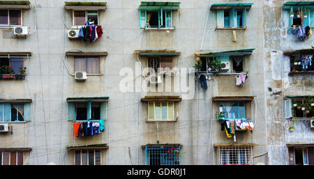 Impressione scena di muro di cemento dal vecchio edificio di appartamenti, gruppo della finestra di età, condizionatore aria e il downgrade di blocco Foto Stock