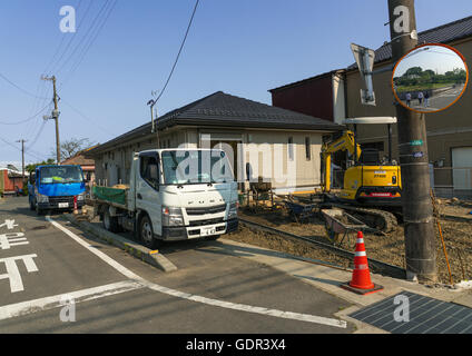 Lavoratori rimuovere la parte superiore del suolo contaminato da radiazioni nucleari di una casa abbandonata nella elevata area contaminata, Fukushima prefettura, Naraha, Giappone Foto Stock