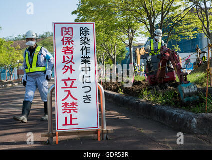 Lavori di decontaminazione nessun segno di entrata nella parte anteriore dei lavoratori che rimuovere la parte superiore del suolo contaminato da radiazioni nucleari dopo la daiichi centrale nucleare esplosione, Fukushima prefettura, Iitate, Giappone Foto Stock