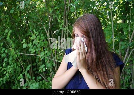 Giovane donna soffia il naso Foto Stock