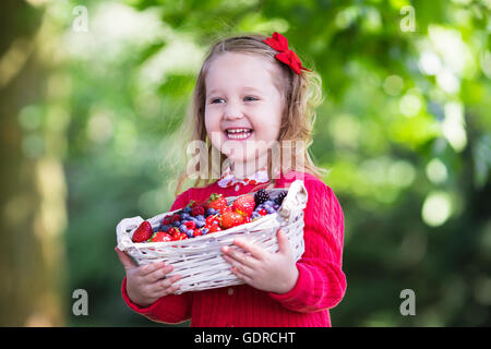 Bambini cherry picking su frutta farm. Bambini Le ciliegie di prelevamento in estate Orchard. Il Toddler kid e baby mangiare frutta fresca Foto Stock