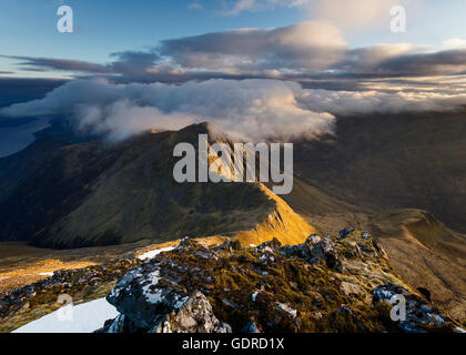 Nuvole che entrano sopra la cima di un lato Sgur nan Saighead, cinque Sorelle di Kintail, Scozia, all'alba Foto Stock