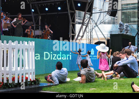 Canary Wharf, Londra, 20 luglio 2016. I londinesi godetevi il concerto gratuito in Canada Square Park. I banchieri, ufficio i lavoratori e le famiglie ascoltato musica classica colpisce con la violinista, Alda Dizdari. La folla ha prodotto i picnic a pranzo e ci siamo goduti il caldo sole estivo. Credito: Eden Breitz/Alamy Live News Foto Stock