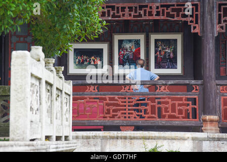 Anshun, della Cina di Guizhou. 22 Luglio, 2016. Un visitatore visualizza presenta durante una mostra fotografica con il tema del 'Anshun agli occhi dei fotografi asiatici' in Anshun, a sud-ovest della Cina di Guizhou, luglio 22, 2016. Un totale di 1.200 le foto sono state visualizzate sull'esposizione. © Liu Xu/Xinhua/Alamy Live News Foto Stock