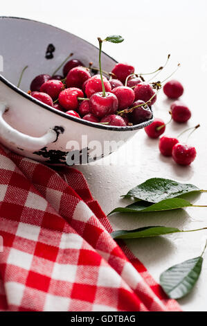 Le ciliege fresche in un vintage recipiente metallico Foto Stock