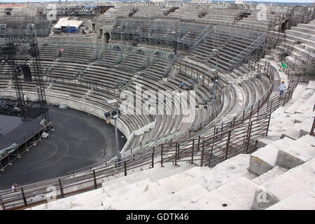 Visitatori l'ascolto di audio guide all'anfiteatro romano di Nimes, Francia Foto Stock