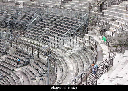 Visitatori l'ascolto di audio guide all'anfiteatro romano di Nimes, Francia Foto Stock