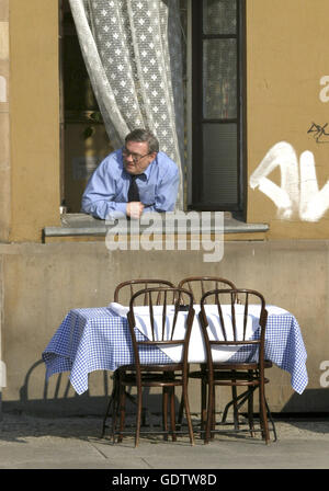 Un uomo in Wroclaw guarda fuori della finestra Foto Stock