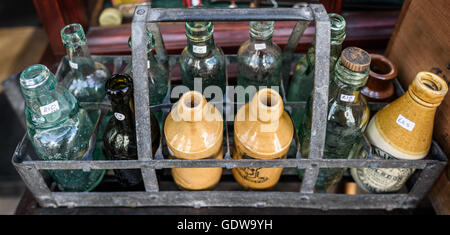 Una selezione di vetro antico e bottiglie in ceramica in un negozio. Foto Stock
