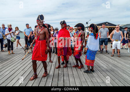 Un gruppo di gente africana in costume tradizionale danza su Hastings Pier durante il giorno pirata Festival, Hastings, Regno Unito Foto Stock