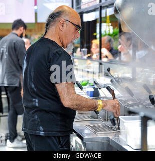 Lo Chef Yisrael Aharoni cottura a sua 'Hiro, stile libero ramen bar' ristorante nel mercato Sarona, Tel Aviv, Israele Foto Stock