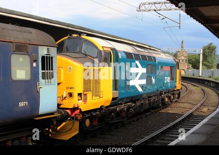 Classe 37 locomotiva diesel-elettriche in British Rail logo grande livrea entrando Carnforth station con un treno passeggeri. Foto Stock