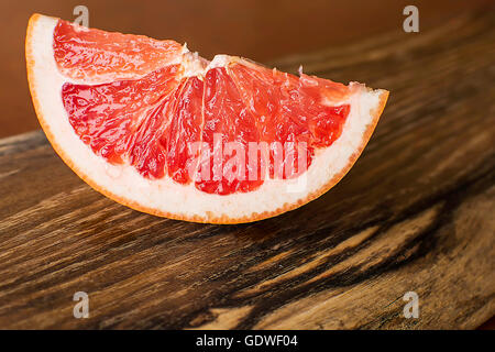 Fetta di Red succosa di pompelmo Vintage sulla tavola di legno Foto Stock