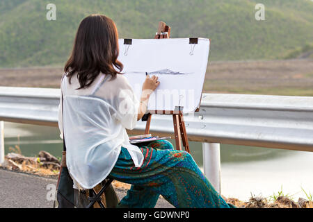 Giovane artista abbozzare un paesaggio, messa a fuoco a portata di mano Foto Stock