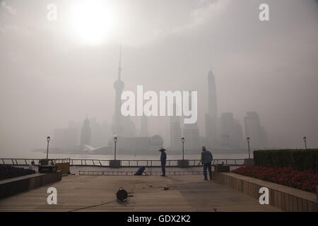 I lavoratori lavorano al Bund sotto aria inquinata al mattino Foto Stock