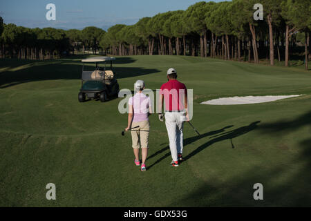 Coppia giovane per raggiungere a piedi il foro successivo sul campo da golf. l uomo che trasportano borsa da golf Foto Stock